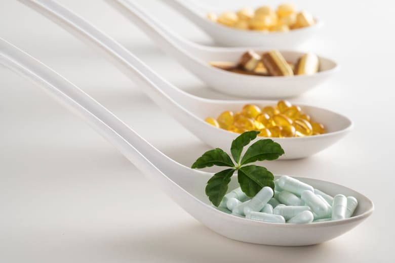 Four spoons filled of supplements diffrent color and shape. As a concept of natural medicines. Preventive medicine.